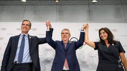 IOC-Präsident Thomas Bach in Jubelpose. Die Spiele 2024 und 2028 gehen nach Paris (rechts Bürgermeisterin Anne Hidalgo) und Los Angeles (links Eric Garcetti).