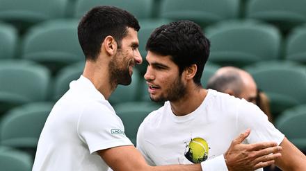 Novak Djokovic und Carlos Alcaraz (r.) übten in Wimbledon beim Training schon mal den Handshake.