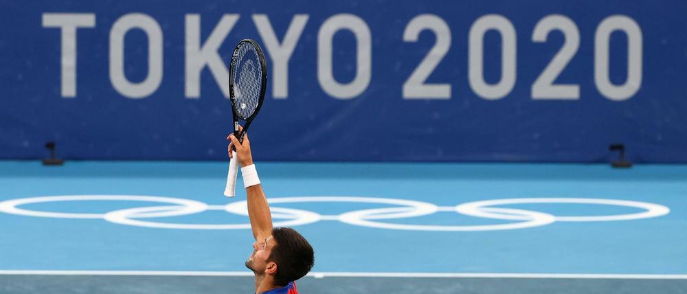 Novak Djokovic jubelt vor dem omnipräsenten Logo der Olympischen Spiele.