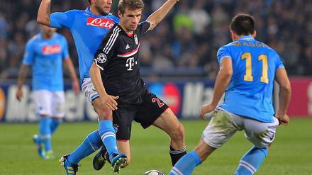 Harter Kampf um den Ball: Bayern Münchens Thomas Müller gegen Christian Maggio (rechts) und Walter Alejandro Guevara Gargano (links)