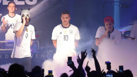 Lukas Podolski (M) posiert in Berlin mit Rapper Cro (l) bei der Trikot-Präsentation des DFB-Ausrüsters im neuen Trikots der deutschen Nationalmannschaft für die EM 2016 in Frankreich. 