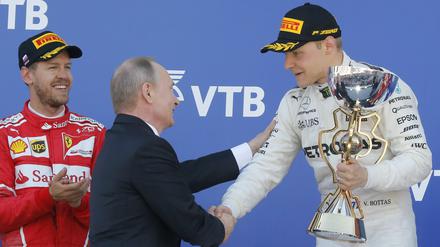 Da gratuliert der König persönlich. Russlands Präsident Wladimir Putin mit Valttteri Bottas (rechts), Sebastian Vettel freut sich derweil (links).