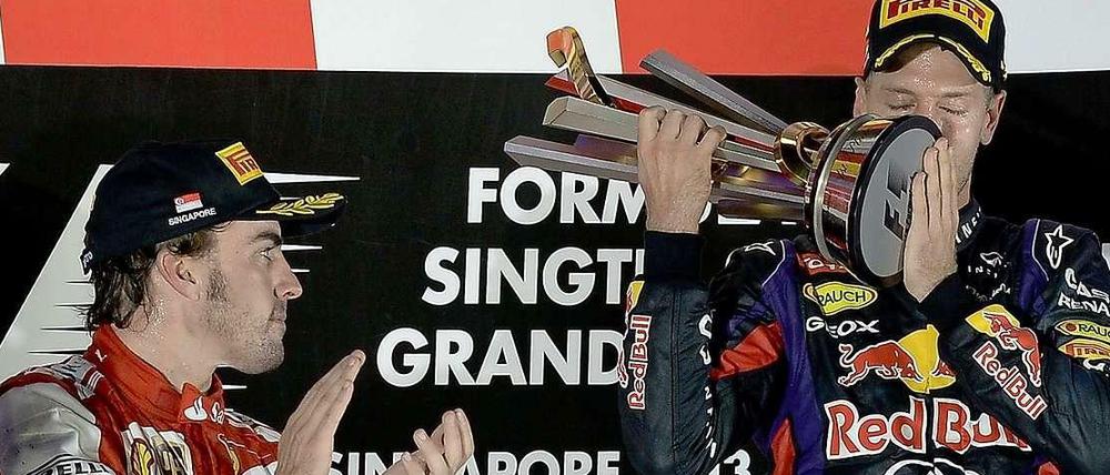 Der obligatorische Kuss: Vettel und die Siegertrophäe nach dem Nachtrennen von Singapur. Alonso applaudiert.