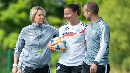 Jetzt geht's los: Bundestrainerin Martina Voss-Tecklenburg und ihr Assistent Patrik Grolimund begrüßen Lena Oberdorf auf dem Rasen.