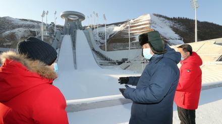 Xi Jinping, Präsident von China, besichtigt das Nationale Skisprungzentrum. Die Regierung hält weiterhin an der Austragung der Spiele fest.