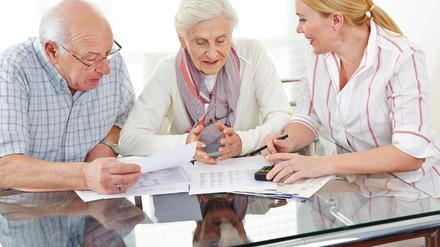 Ein Paar Senioren bekommt Beratung zu Finanzthemen am Tisch