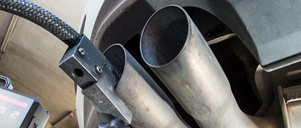 Ein Messschlauch eines Geräts zur Abgasuntersuchung für Dieselmotoren steckt im Auspuffrohr eines VW Golf.