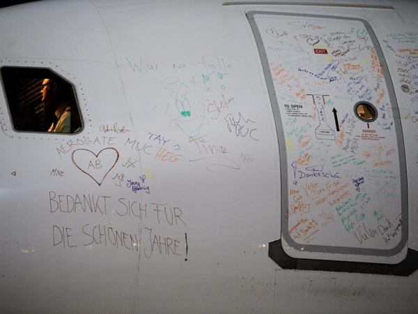 Zahlreiche Unterschriften von Crewmitgliedern und Fluggästen am Flugzeug. 