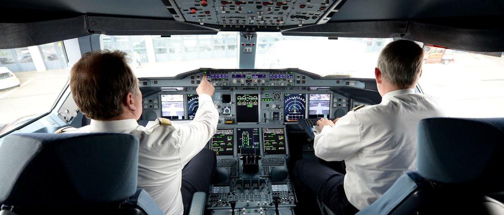 Zwei Piloten sitzen am 05.06.2014 auf dem Flughafen in Hamburg im Cockpit eines Lufthansa-Airbus A380. Das Flugzeug wurde auf den Namen "Hamburg" getauft. Foto: Daniel Reinhardt/dpa +++(c) dpa - Bildfunk+++