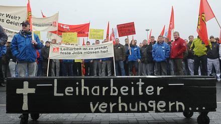 Mit einem "Sarg für Leiharbeiter", Fahnen und Transparenten nehmen einige hundert Belegschaftsmitglieder des VW-Werks an einer Kundgebung der IG Metall Küste zur Leiharbeitsbranche teil. 