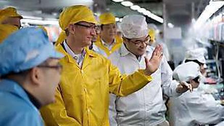 Ganz in Gelb: Apple-Chef Tim Cook beim Besuch von Foxconn, wo das Unternehmen einen Teil seiner Geräte produzieren lässt.