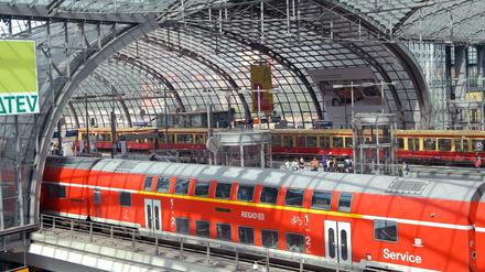 Im Berliner Hauptbahnhof stehen eine S-Bahn und ein Regionalzug. 