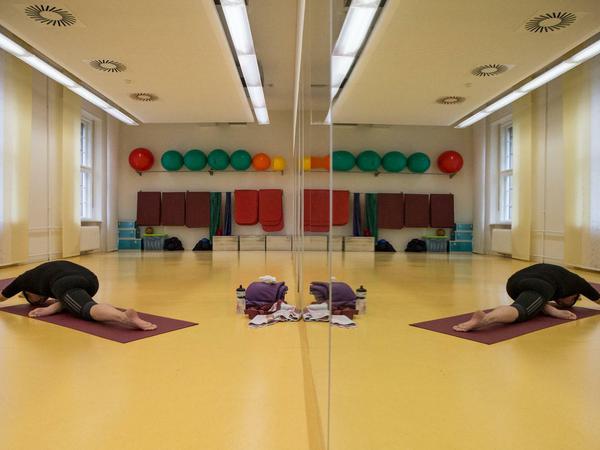 Ein Siemens-Mitarbeiter beim Yoga im betriebsinternen Fitnessstudio in Berlin. 
