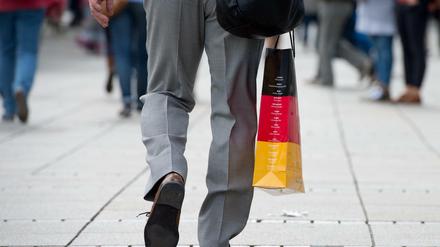 Ein Mann trägt eine Tasche in den deutschen Nationalfarben.