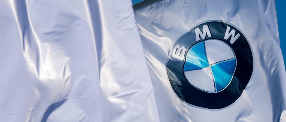Fahnen mit dem Logo von BMW wehen am Olympiapark in München.