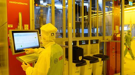 Ein Bosch-Mitarbeiter in der neuen Halbleiterfabrik im Reinraum an einer Maschine für die Bestückung von 300-Millimeter-Wafern. 