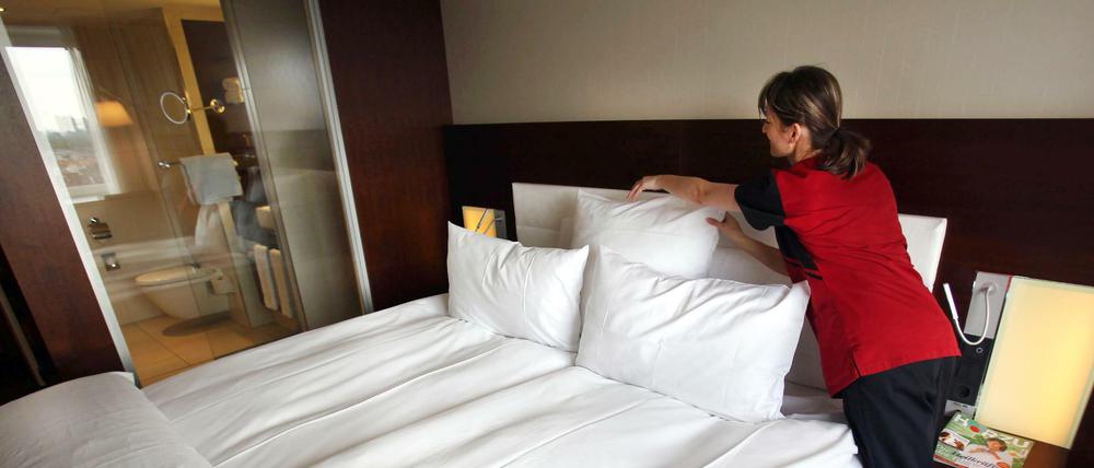 Ein Zimmermädchen macht in Köln in einem Hotel das Bett (Symbolbild).