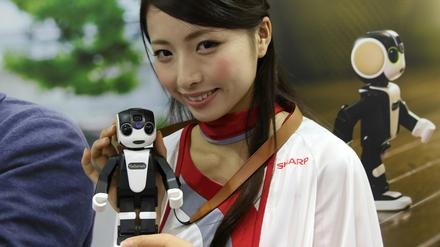 Eine Hostesse zeigt auf Japans führender Unterhaltungselektronik-Messe, Ceatec den kleinen Roboter RoBoHoN.