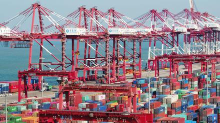 China, Qingdao: In einem Hafen stehen Container und Containerbrücken.