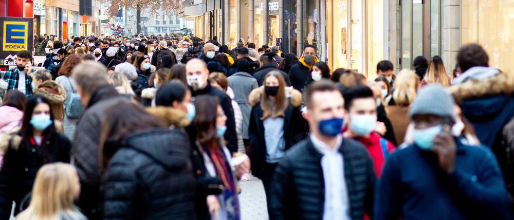 Zahlreiche Menschen gehen mit Mund-Nasen-Bedeckung dicht gedrängt durch die Innenstadt in Hannover.