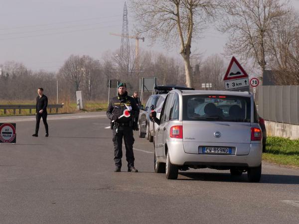 Italienische Polizisten sperren eine Zufahrtsstraße. Ungeachtet drastischer Maßnahmen zur Eindämmung steigt die Zahl der Infektionen mit dem Coronavirus in Italien weiter.