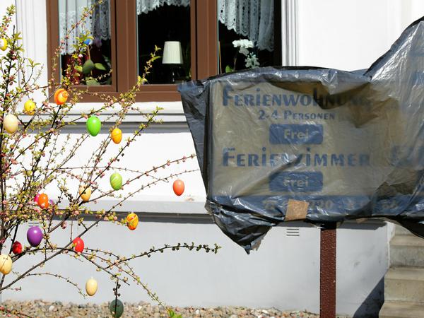 Das Schild vor einem Haus mit Ferienwohnungen in Wustrow ist am 07.04.2020 mit einer Plastiktüte verhüllt.