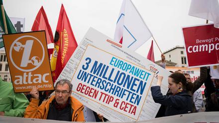 Verschiedene Aktionsbündnisse stehen mit Fahnen und Transparenten vor dem Brandenburger Tor in Berlin, um für eine geplante Großdemonstration am 10.10.2015 gegen die Handelsabkommen TTIP und CETA zu werben. 
