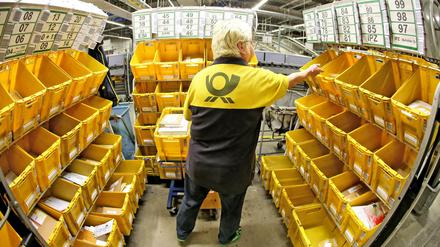Eine Mitarbeiterin der Deutschen Post sortiert Großbriefe im Briefzentrum.