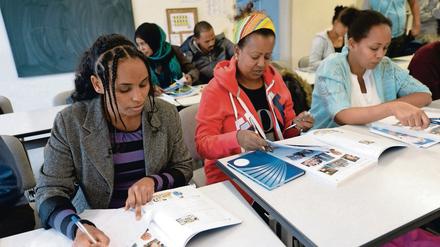 Flüchtlinge aus Syrien, Eritrea, Iran und Irak nehmen an einem Deutschkurs teil. 