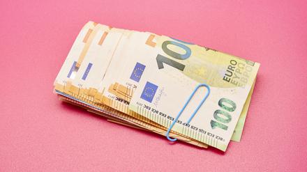 Directly above shot of a bundle of Euro bank notes on pink background