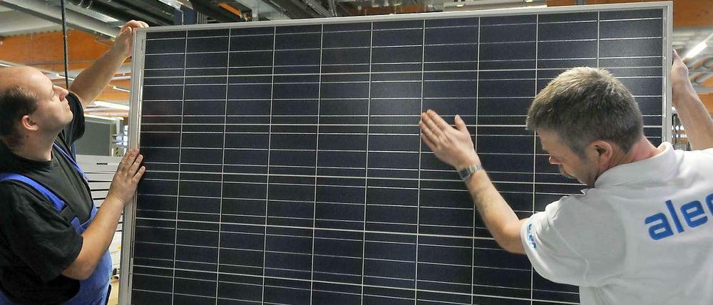 Alles palett? Zwei Mitarbeiter der aleo solar AG in Prenzlau kontrollieren hier ein Solarmodul nach der Fertigstellung. Diese Qualitätskontrolle war offenbar nicht immer ausreichend. 