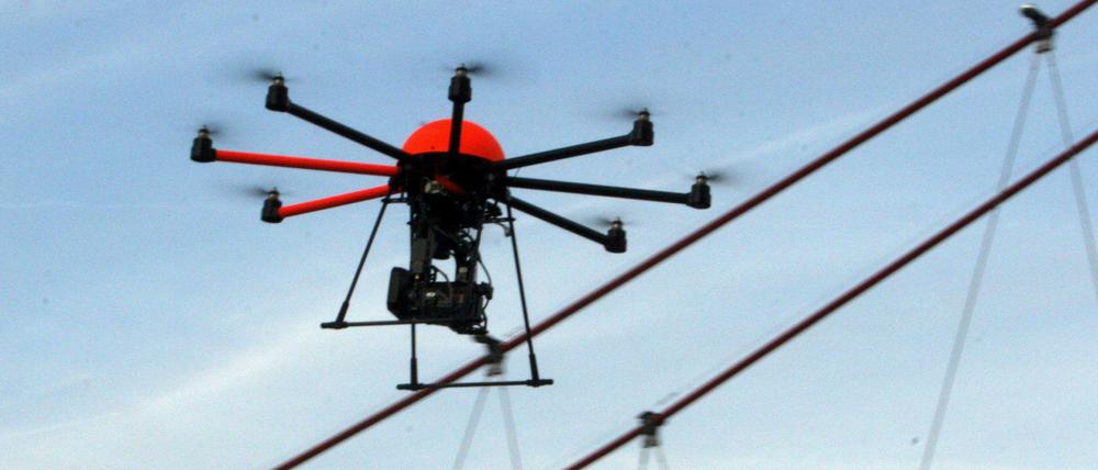Mit einer anmontierten Kamera schwebt eine Drohne eines Fotografen in Frankfurt am Main durch die Luft.
