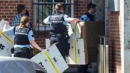 Polizisten mit Pappkartons vor dem Porsche-Gebäude.