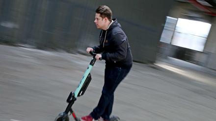 Ein Mann fährt auf einem Testgelände mit einem Elektro Roller (E-Scooter).