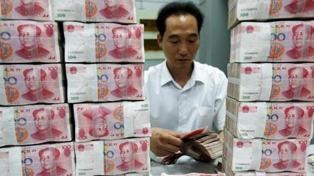 Ein chinesischer Bankangestellter zählt Geldscheine 