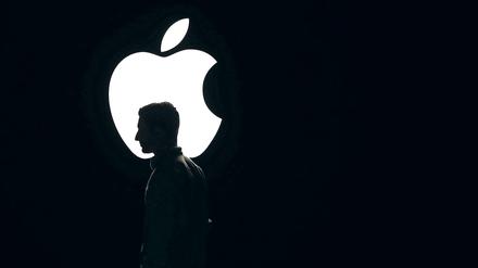 Eine Person steht vor dem Apple-Logo.