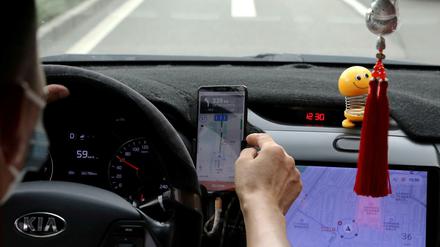 Ein Fahrer in Peking nutzt die App des Fahrdienstleisters Didi, der ins Kreuzfeuer der chinesischen Aufsichtsbehörden geraten ist.
