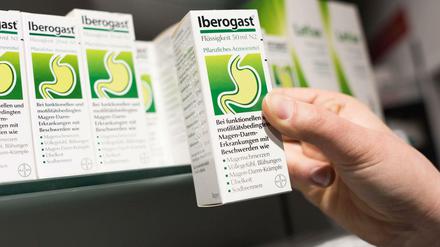Eine Apothekerin hält das rezeptfreie Magenmittel IBEROGAST in der Hand. 