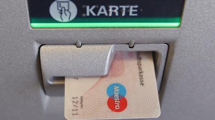 Eine EC-Karte steckt im Eingabeschlitz eines Geldautomaten.