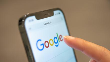 Eine Frau nutzt auf dem Handy die Suchmaschine von Google.