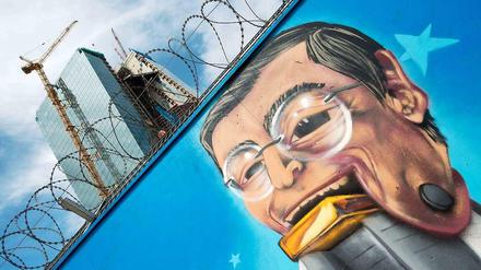 Nimmersatt: Ein Graffitti am Bauzaun des Neubaus der Europäischen Zentralbank (EZB) in Frankfurt zeigt EZB-Chef Mario Draghi mit einem Goldbarren im Mund.