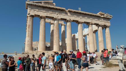 Urlauber besichtigen die Akropolis in Athen.