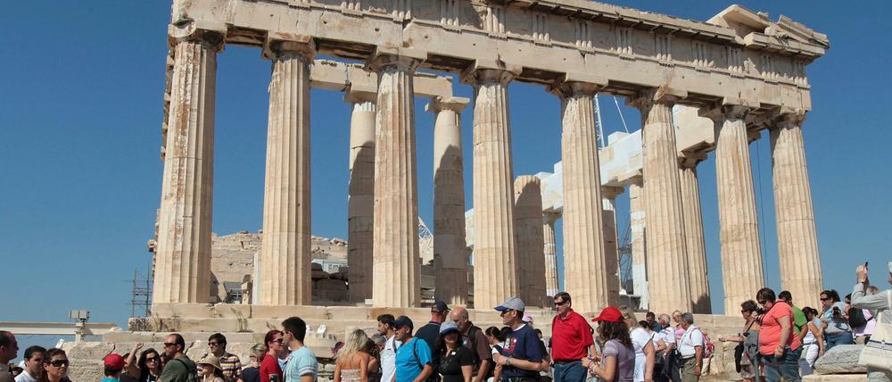 Urlauber besichtigen die Akropolis in Athen.