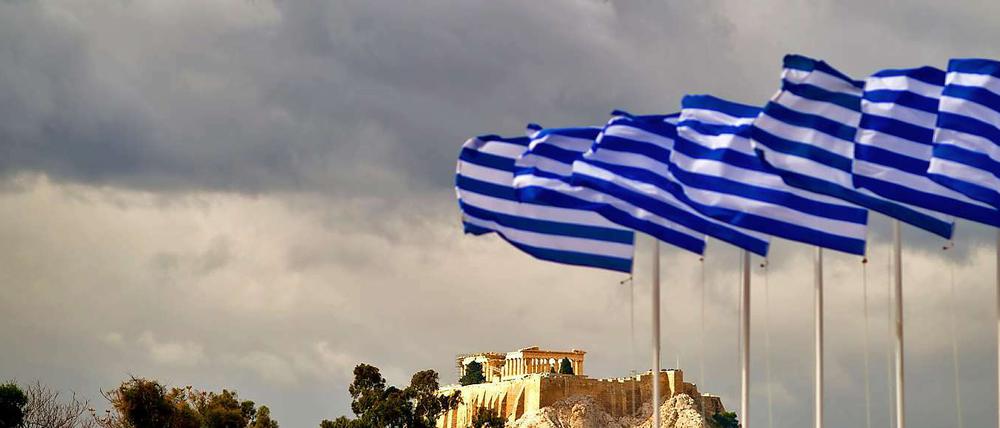 Griechische Fahnen wehen in Athen am Panathinaiko-Stadion vor der Akropolis