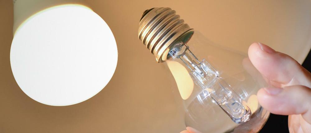 An einer Deckenleuchte wird eine Halogenlampe (r) gegen eine energiesparende LED-Lampe ausgewechselt.