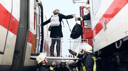 Zug um Zug. Auf diesem Bild sieht man Feuerwehrleute, die Passagieren eines liegen gebliebenen ICEs helfen, in einen Intercity zu steigen. 