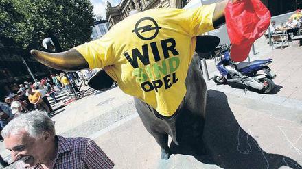 „Wir sind die Realwirtschaft.“ Opel-Mitarbeiter demonstrierten vor der Frankfurter Börse. Dort stehen Bulle und Bär als Symbol für steigende und fallende Aktienkurse. Foto: ddp