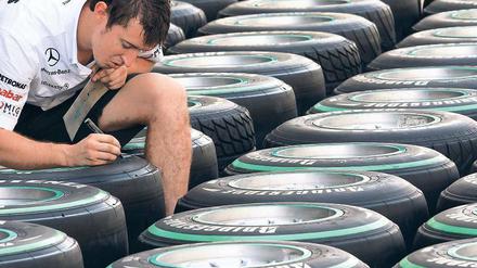 Kein heißer Reifen. Ein Mercedes-Mechaniker markiert auf der Formel-1-Strecke von Abu Dhabi Rennreifen. Foto: dpa