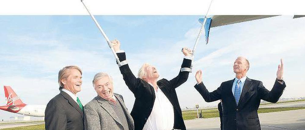 Preiset die Herren. Virgin-Gründer Richard Branson hebt die Krücken, Airbus-Chef Thomas Enders die Arme, und auch zwei Untergebene machen auf Show.