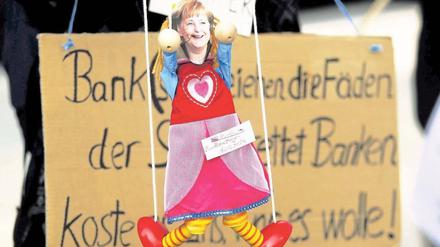 Nur eine Marionette. So sehen jedenfalls Occupy-Demonstranten in Frankfurt am Main Bundeskanzlerin Angela Merkel. Foto: dapd